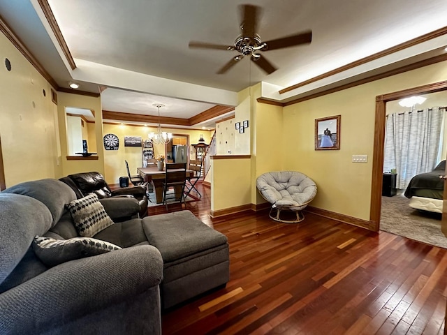 living area featuring crown molding, baseboards, ceiling fan with notable chandelier, and dark wood-type flooring