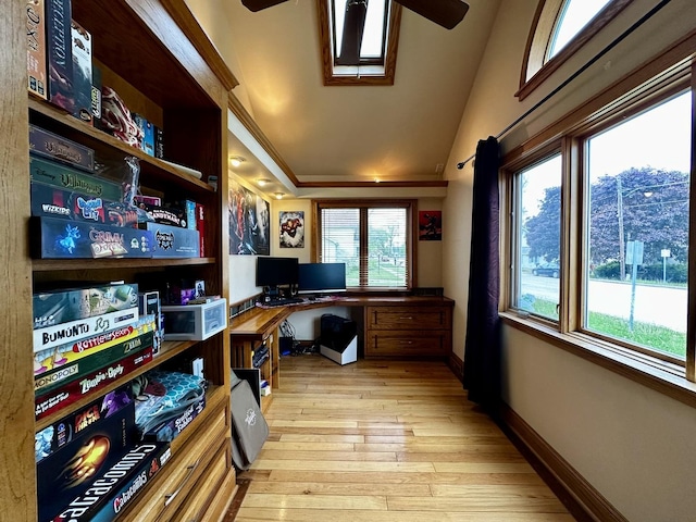 office space with a ceiling fan, baseboards, vaulted ceiling, and light wood-style flooring