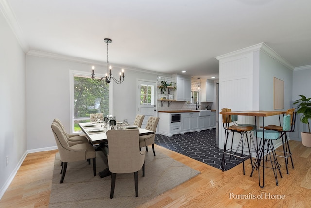 232 S Randall Rd, Aurora, IL 60506 - dining space with a chandelier, crown molding, light wood-type flooring, and baseboards