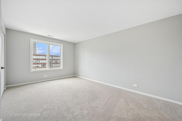 carpeted spare room featuring baseboards