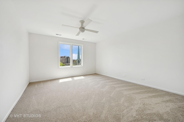 spare room with carpet flooring, baseboards, and a ceiling fan
