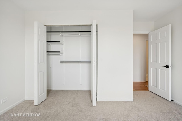unfurnished bedroom with carpet flooring, a closet, and baseboards