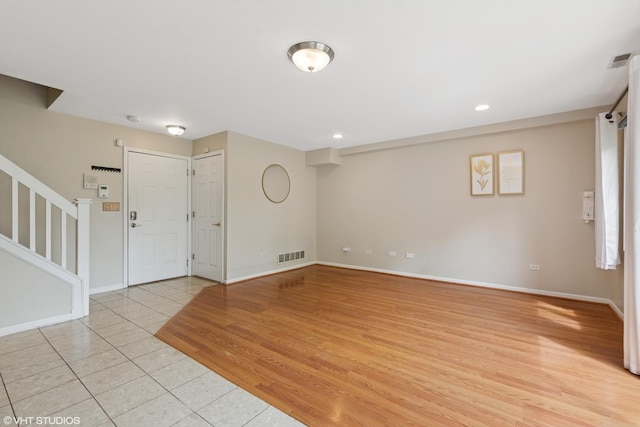 entrance foyer with stairway, light tile patterned flooring, baseboards, and visible vents