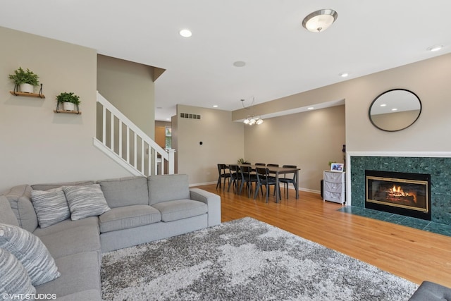 living room featuring wood finished floors, a fireplace, visible vents, stairway, and recessed lighting
