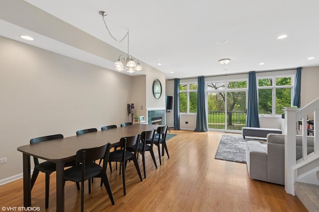 dining space with an inviting chandelier, stairway, light wood-style flooring, and recessed lighting