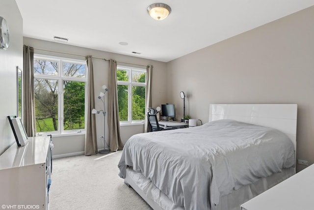 bedroom featuring light colored carpet, visible vents, and baseboards