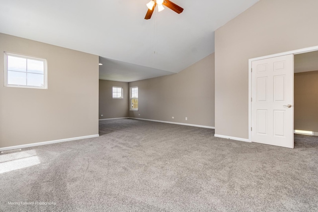 spare room with vaulted ceiling, baseboards, carpet, and a ceiling fan