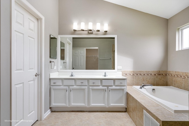 bathroom with a sink, a garden tub, double vanity, and visible vents