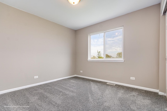 carpeted empty room featuring baseboards and visible vents