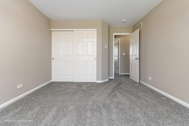 unfurnished bedroom featuring carpet floors, baseboards, visible vents, and a closet