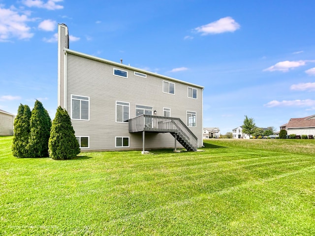 rear view of property featuring stairs, a chimney, a yard, and a deck