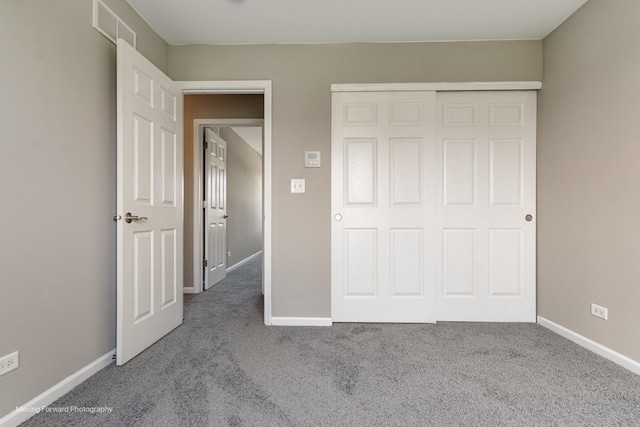 unfurnished bedroom with baseboards, carpet, a closet, and visible vents