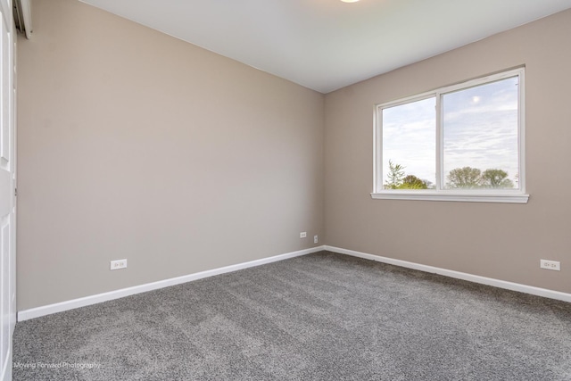 carpeted empty room featuring baseboards