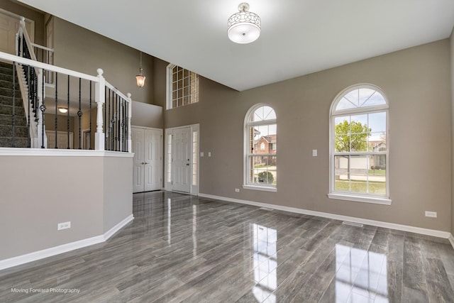 entryway featuring baseboards, stairs, wood finished floors, and visible vents