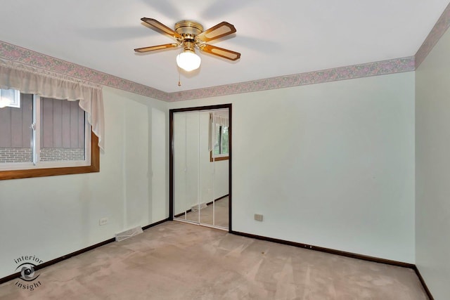 unfurnished bedroom with ceiling fan, light carpet, baseboards, visible vents, and a closet