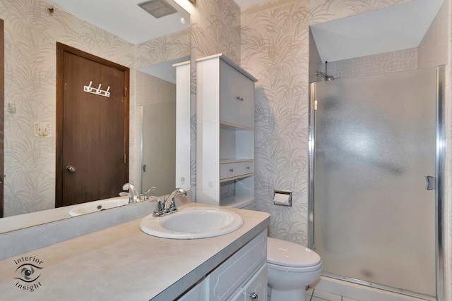bathroom with vanity, a stall shower, wallpapered walls, and toilet