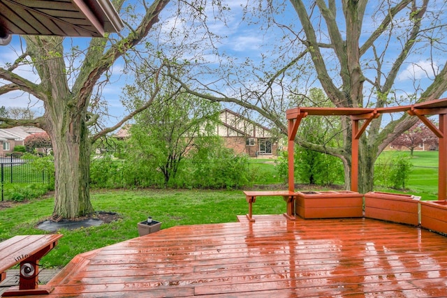 wooden deck featuring a yard and fence