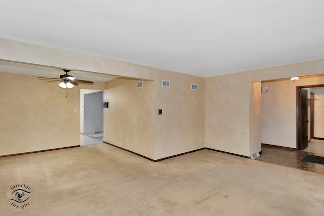 empty room with visible vents, a ceiling fan, baseboards, and light carpet