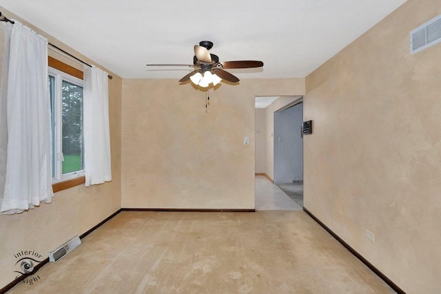 spare room featuring baseboards, ceiling fan, light colored carpet, and visible vents