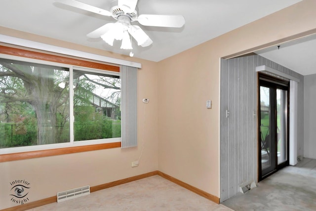 empty room with baseboards, a ceiling fan, and visible vents