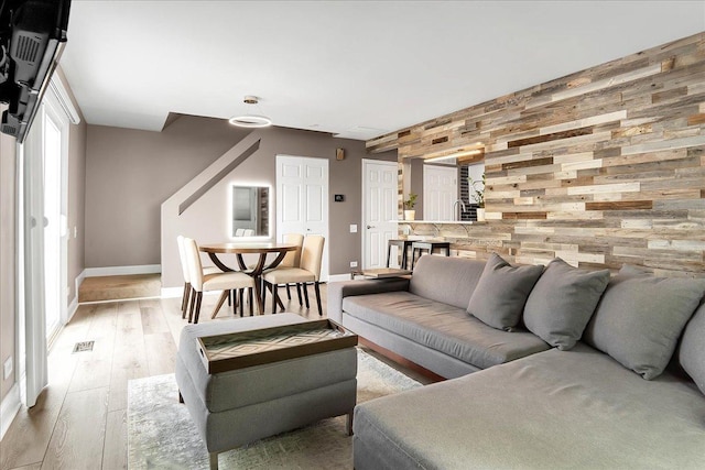 436 Yorktown Ct, Aurora, IL 60504 - living area featuring baseboards, visible vents, wood walls, and light wood-style floors