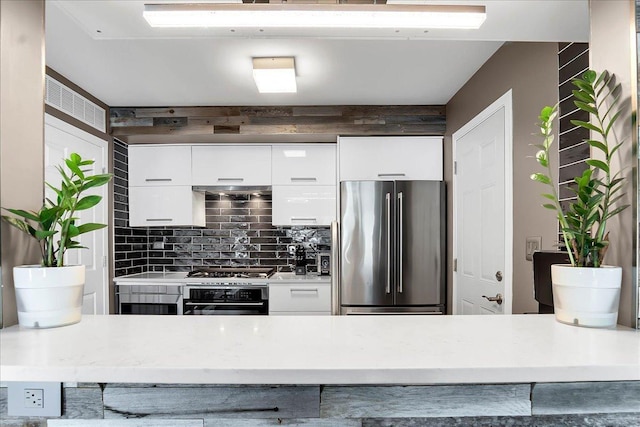 436 Yorktown Ct, Aurora, IL 60504 - kitchen featuring backsplash, wall oven, light countertops, white cabinets, and freestanding refrigerator