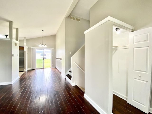 foyer with wood-type flooring, a chandelier, vaulted ceiling, baseboards, and stairs