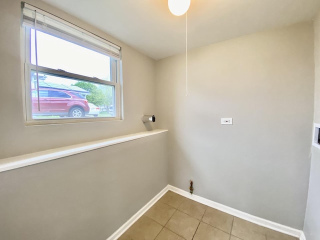 laundry room with baseboards and light tile patterned flooring