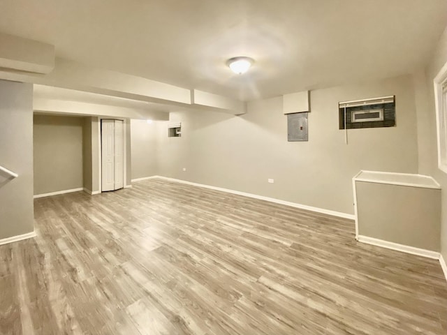 finished basement with baseboards, wood finished floors, and electric panel