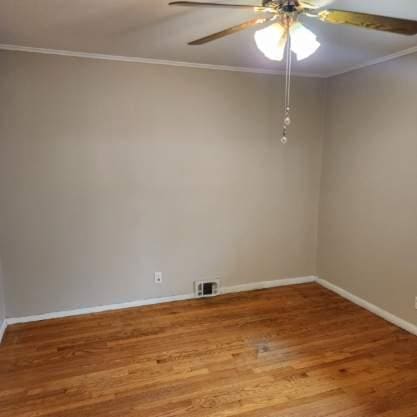 5900 W 110th St, Chicago Ridge, IL 60415 - unfurnished room featuring ceiling fan, wood finished floors, baseboards, and ornamental molding