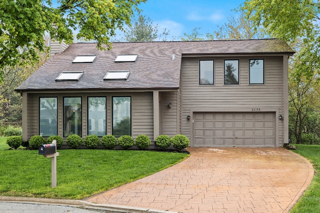 split level home with a garage, a front lawn, decorative driveway, a chimney, and a shingled roof