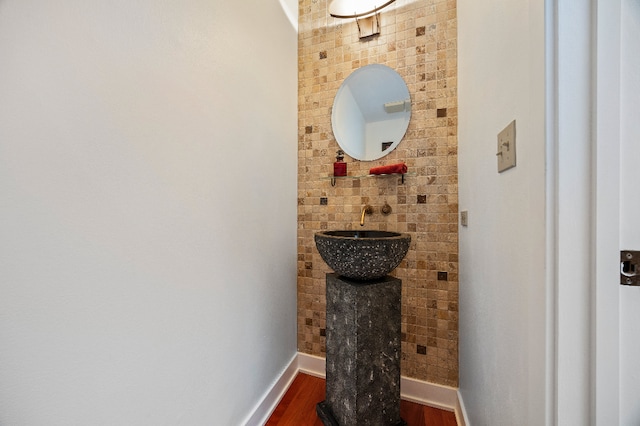 bathroom with a sink, baseboards, and wood finished floors