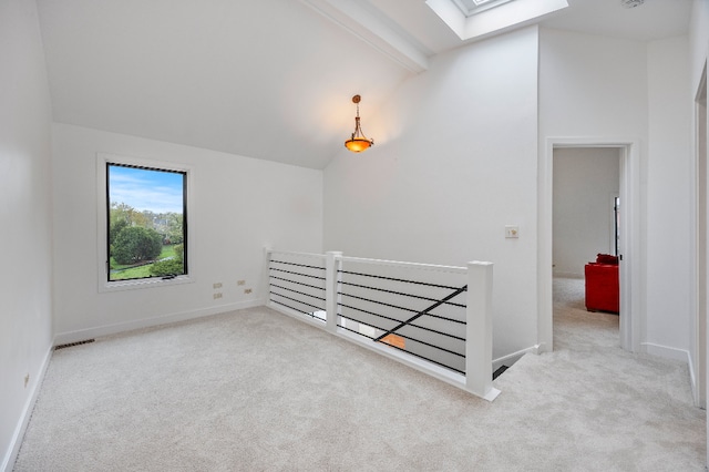 additional living space with carpet floors, baseboards, and vaulted ceiling with skylight