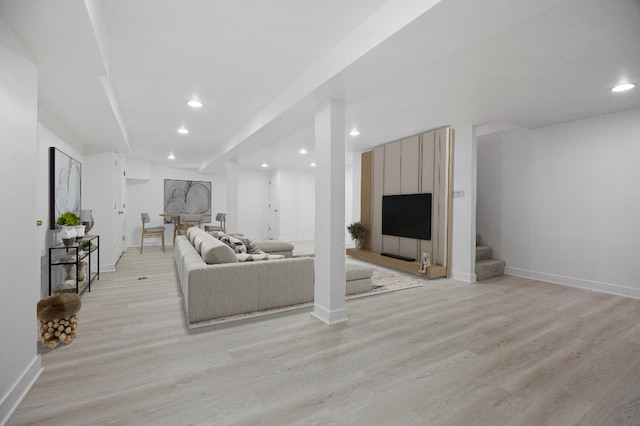 living room featuring baseboards, light wood finished floors, recessed lighting, and stairs