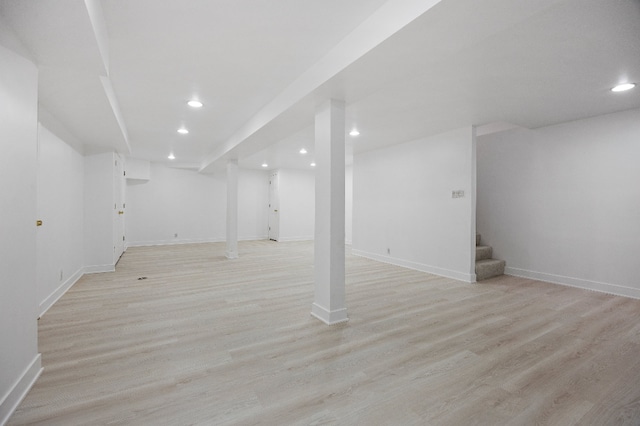 finished basement featuring stairs, recessed lighting, baseboards, and light wood-style flooring