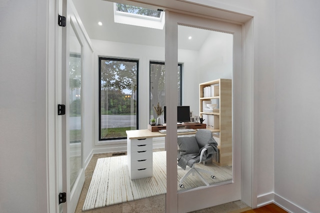home office featuring a skylight, baseboards, and a healthy amount of sunlight