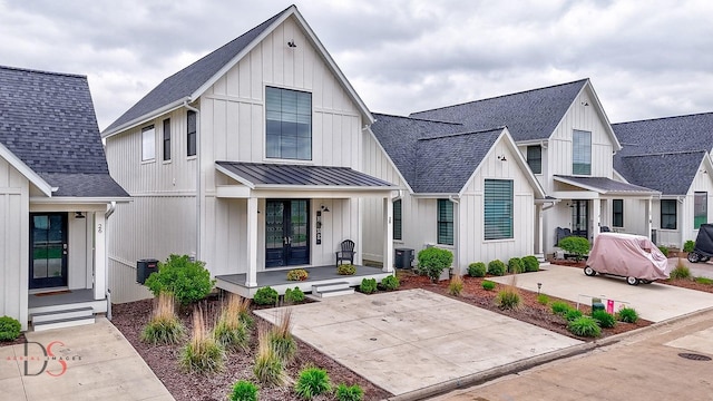 view of front of house with central air condition unit, roof with shingles, a standing seam roof, and french doors
