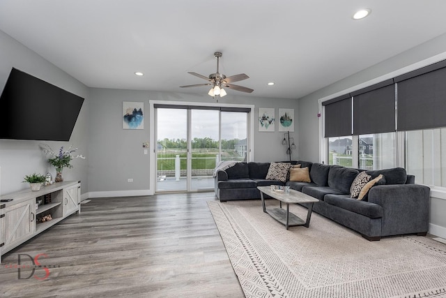 living area with light wood-style floors, baseboards, ceiling fan, and recessed lighting