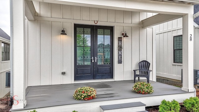 view of exterior entry with french doors and board and batten siding