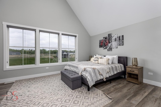 bedroom featuring visible vents, wood finished floors, baseboards, and high vaulted ceiling