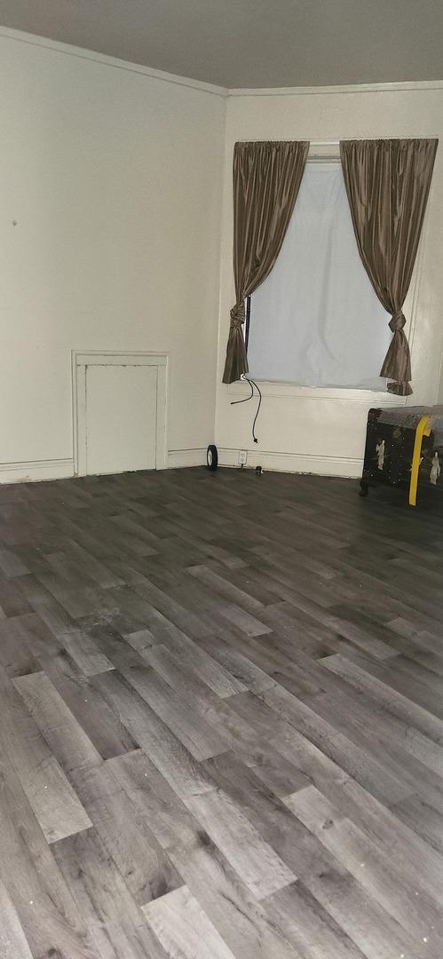 7943 S Vernon Ave, Chicago, IL 60619 - empty room with wood finished floors and crown molding
