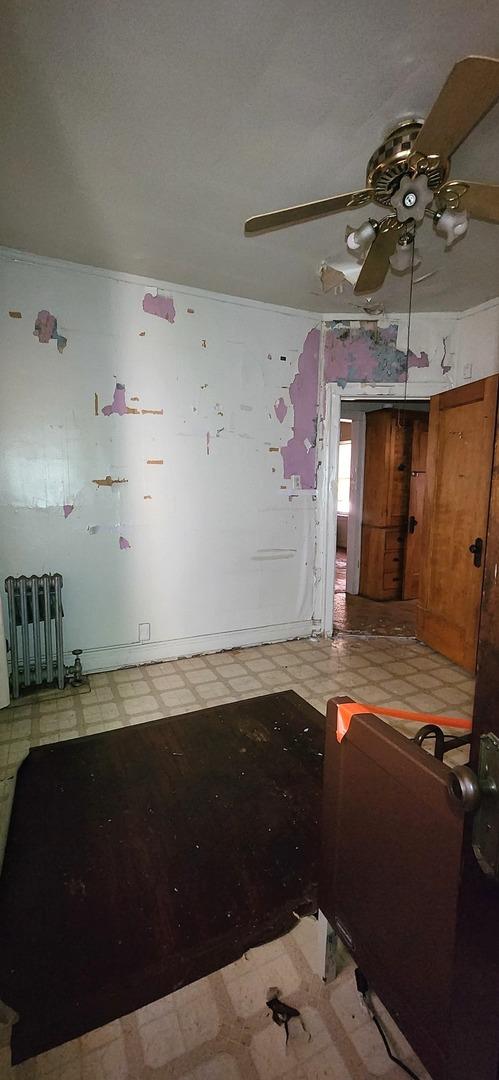 7943 S Vernon Ave, Chicago, IL 60619 - unfurnished room featuring tile patterned floors, radiator, and a ceiling fan