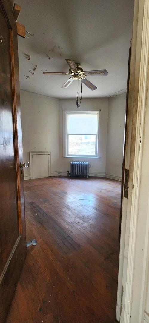 7943 S Vernon Ave, Chicago, IL 60619 - spare room with radiator, hardwood / wood-style flooring, and ceiling fan