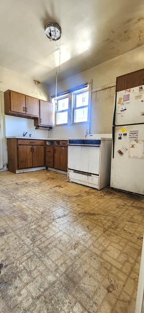 7943 S Vernon Ave, Chicago, IL 60619 - kitchen with freestanding refrigerator, brown cabinets, light countertops, and dishwasher