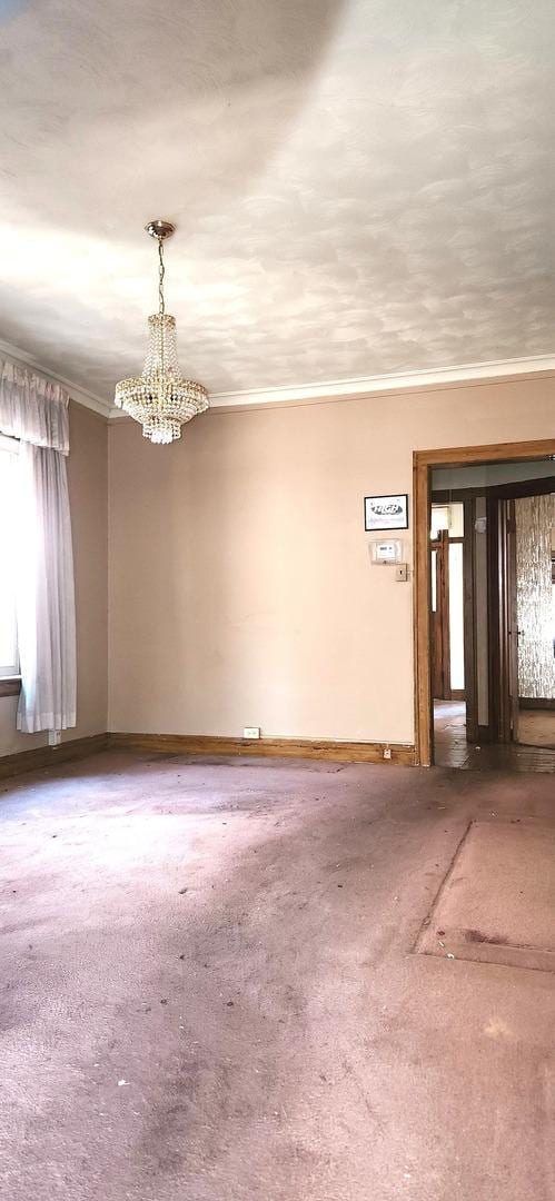 7943 S Vernon Ave, Chicago, IL 60619 - empty room with crown molding, carpet floors, a chandelier, and baseboards