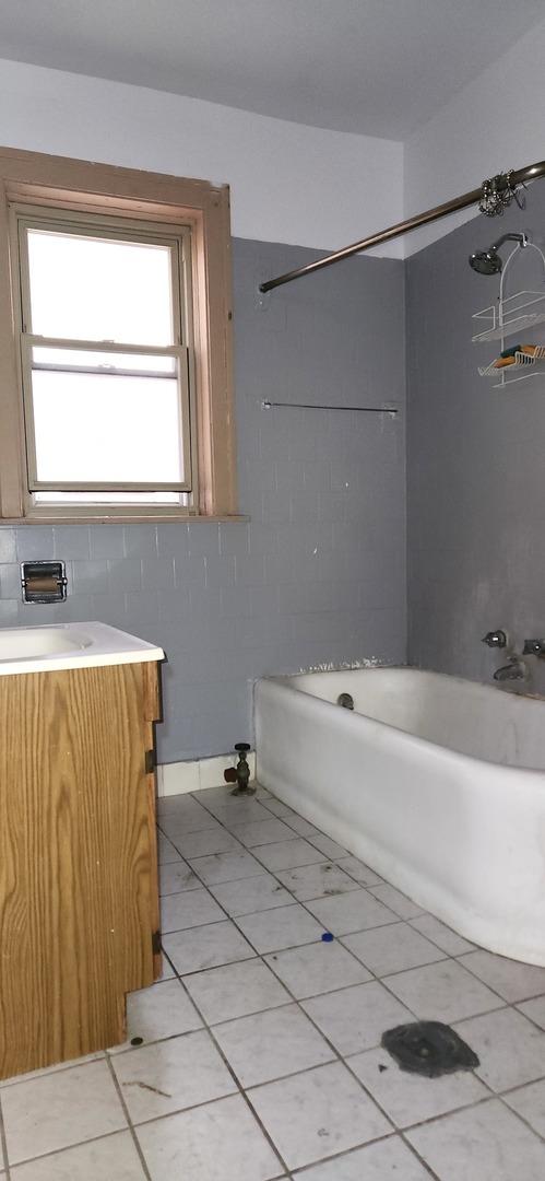 7943 S Vernon Ave, Chicago, IL 60619 - bathroom featuring vanity, bathtub / shower combination, and tile patterned flooring