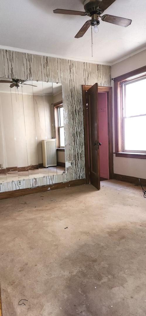 7943 S Vernon Ave, Chicago, IL 60619 - unfurnished living room featuring ceiling fan and concrete flooring