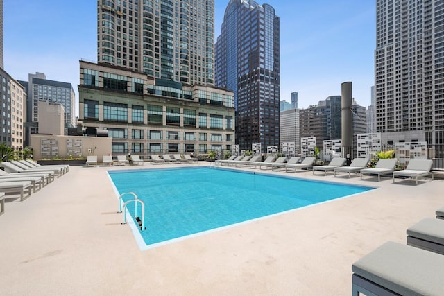 community pool with a city view and a patio