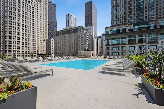 community pool featuring a patio area and a view of city