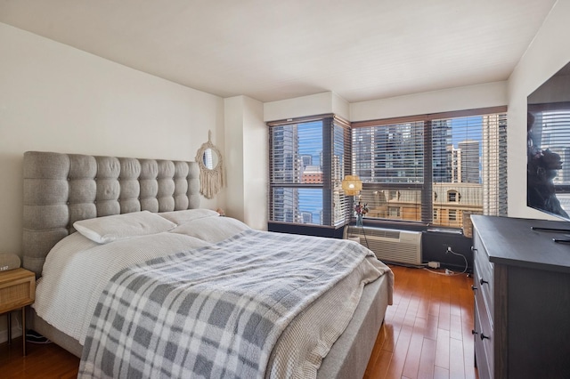 bedroom with multiple windows and hardwood / wood-style flooring